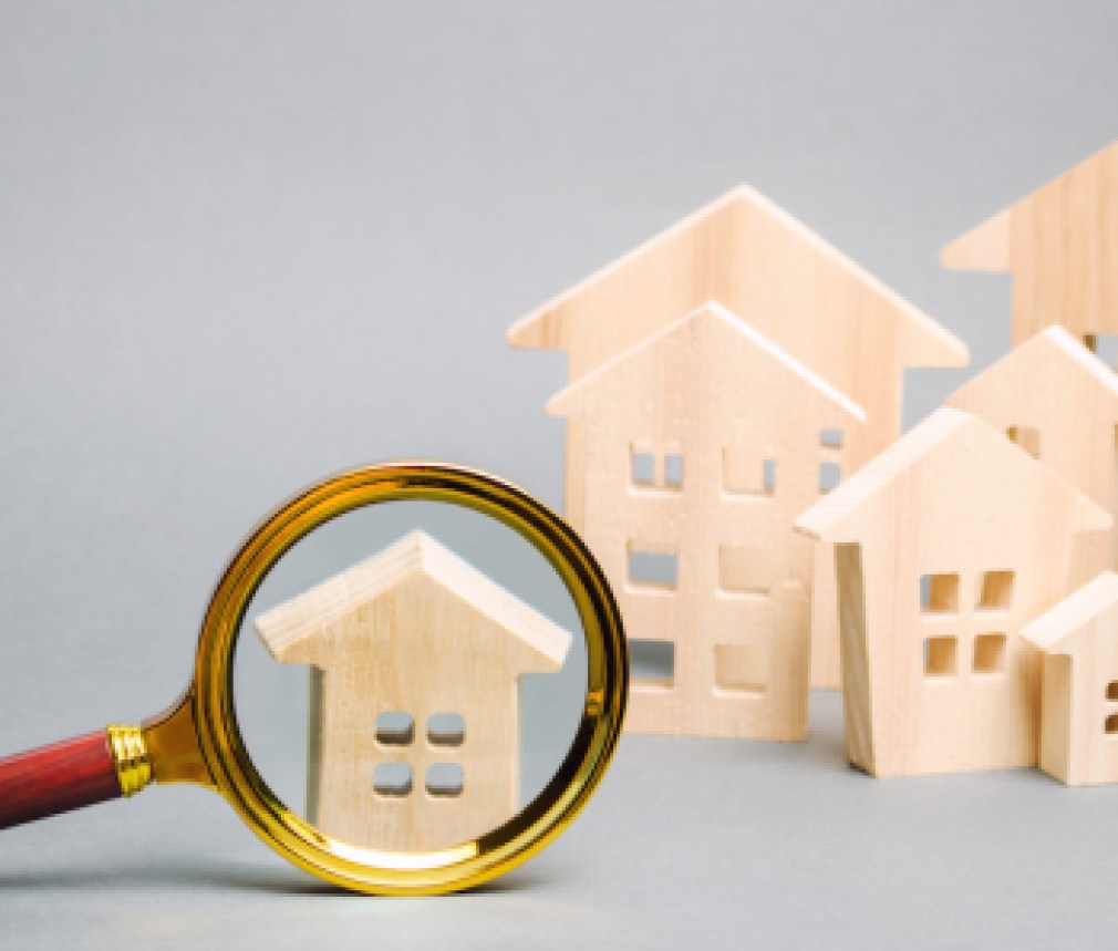 Magnifying glass and wooden houses. House searching concept. Home appraisal. Property valuation. Choice of location for the construction. Search for housing, apartments. Real estate appraiser services